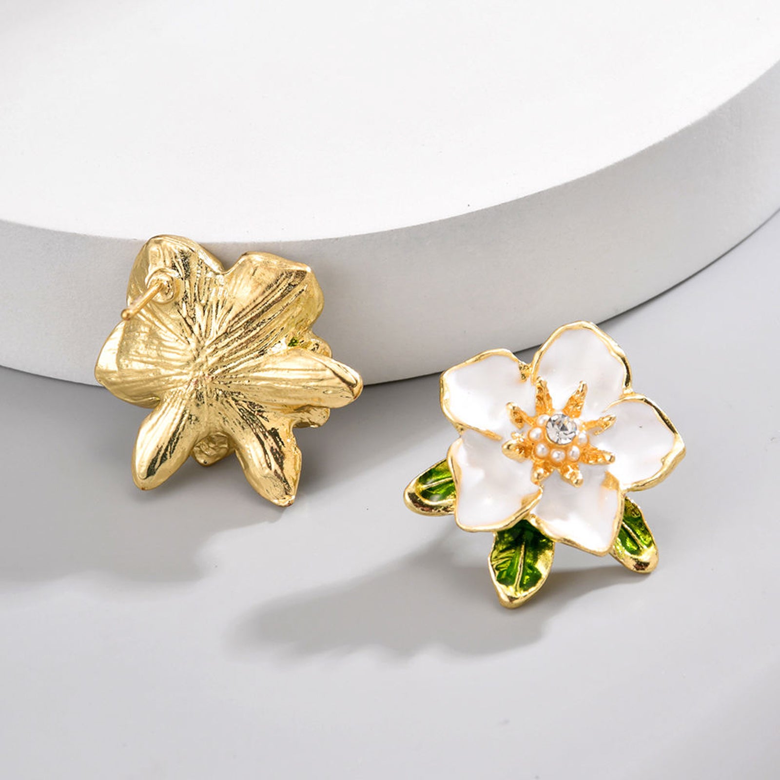 Elegant White Enamel Flower Stud Earrings – Gold-Toned Floral Statement Jewelry with Crystal Center and Green Leaf Accents
